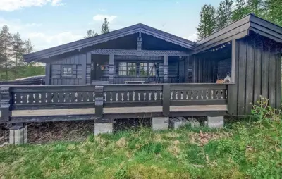 a house with a large porch on a field at Koselig Fjellhytte Med Utsikt in Bykle