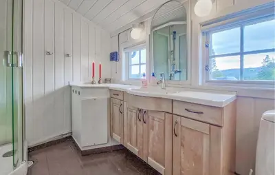a white bathroom with a sink and a window at Koselig Fjellhytte Med Utsikt in Bykle