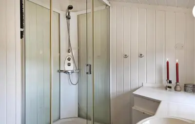 a bathroom with a shower and a toilet and two red candles at Koselig Fjellhytte Med Utsikt in Bykle