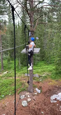 a person is climbing a tree on a zip line at Cozy 2-Bedroom Retreat In The Heart Of Nature in Beitostøl