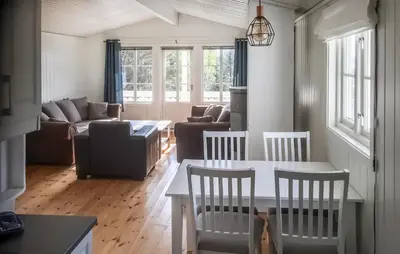 a living room with a table and chairs and a couch at 3 Bedroom Nice Home In Kvenvær in Kvenvær