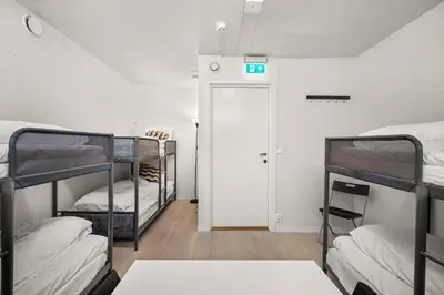 a room with three bunk beds and a door at BUDGETEL- Kong Oscarsgate 48 in Bergen