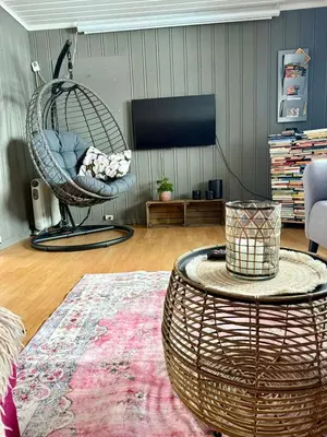 a living room with a wicker swing chair and a table at Koia Guesthouse in Flesberg