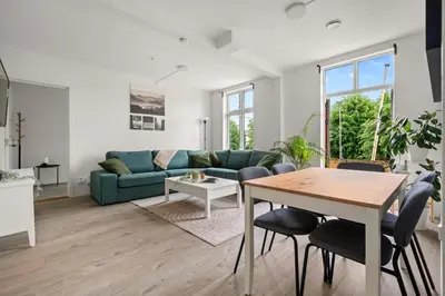 a living room with a blue couch and a table at One of a kind in Bergen I 7 Bedrooms I 15 Guests! in Bergen