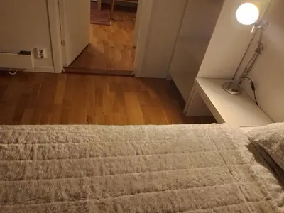 a bedroom with a bed with a lamp next to it at Cosy apartment near city center in Bergen