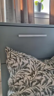 a bed with a pillow in front of a window at Feriehus i Lærdal in Mjeldo