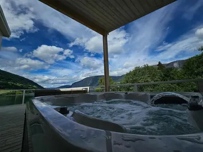 a jacuzzi tub with a view of the mountains at Modern cabin with panorama view in Olden
