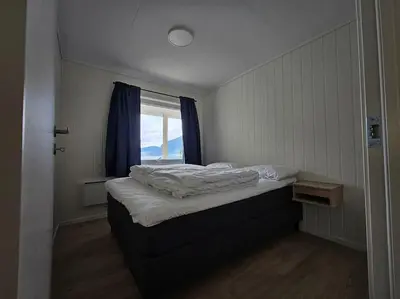 a bed in a room with a window at Modern cabin with panorama view in Olden