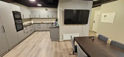 a kitchen with a large flat screen tv on the wall at Lilleby Apartment in Trondheim