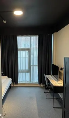a room with a bed and a desk and a window at Lilleby Apartment in Trondheim