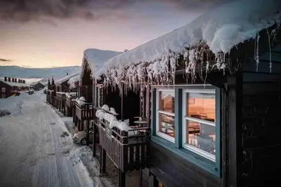 a building covered in snow with icicles on the roof at Rekkehus i Myrkdalen in Helgatun