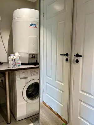 a washing machine in a kitchen next to a door at Cozy Central Apartment in Ålesund in Ålesund