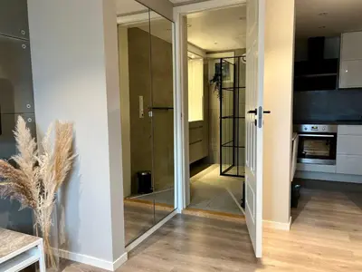 a hallway with a glass door leading to a kitchen at Cozy Central Apartment in Ålesund in Ålesund