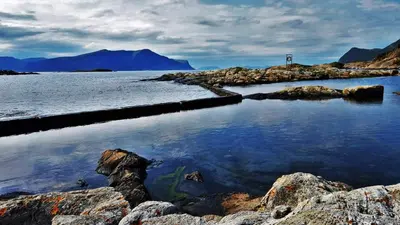 a large body of water with rocks and mountains at Cozy Central Apartment in Ålesund in Ålesund