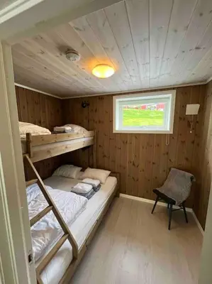 a small room with a bunk bed and a chair at Leilighet Overøye Hyttegrend in Stordal