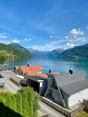 a house on a lake with mountains in the background at Stryn - Faleide - hus ved fjorden in Stryn