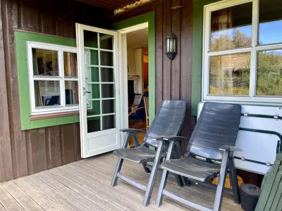 two chairs sitting on the front porch of a house at Spacious Apartment In Central Beitostølen in Beitostøl