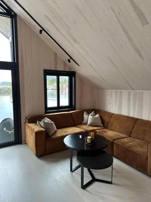 a living room with a brown couch and a table at Amundøya Penthouse in Kristiansund