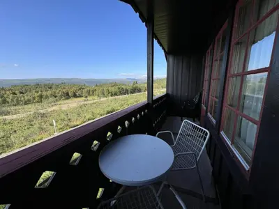 a table and chairs on a balcony with a view at 2-Bedroom Apartment With Balcony & Fireplace! in Beitostøl