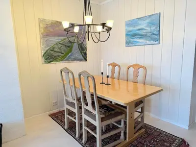 a dining room table with four chairs and a chandelier at 2-Bedroom Apartment With Balcony & Fireplace! in Beitostøl