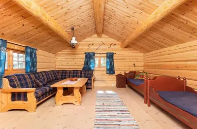 a living room of a log cabin with a couch and a table at Skogcamping in Bjørnstad