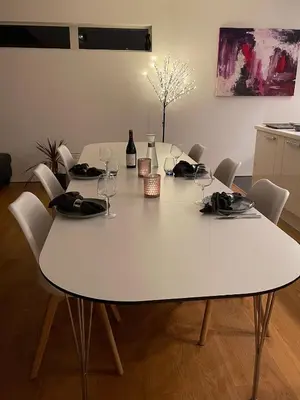 a white table with chairs and wine glasses on it at Nydelig villa ved sjøen med oppvarmet basseng in Bergen