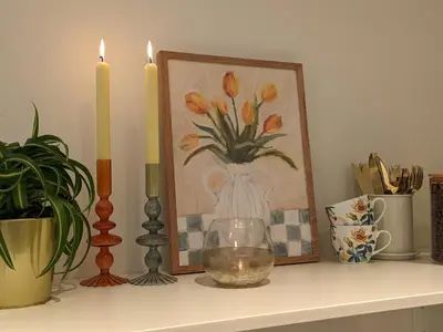 a shelf with two candles and a picture and a vase at Meget hjemmekoseligISentraltINyoppusset leilighet in Bergen