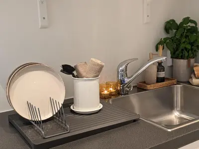 a kitchen counter with a sink and a mirror at Meget hjemmekoseligISentraltINyoppusset leilighet in Bergen