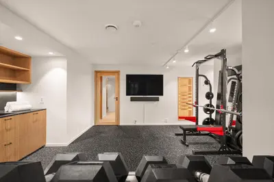 a gym with a treadmill and a flat screen tv at Hopsneset Luxury Villa in Bergen