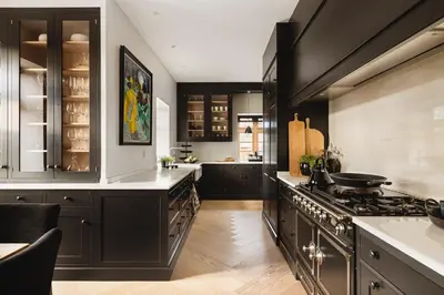a kitchen with black cabinets and a stove at Hopsneset Luxury Villa in Bergen