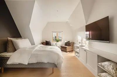a white bedroom with a bed and a tv at Hopsneset Luxury Villa in Bergen