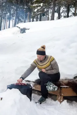 a woman sitting on a bench in the snow at GapaLux in Levanger