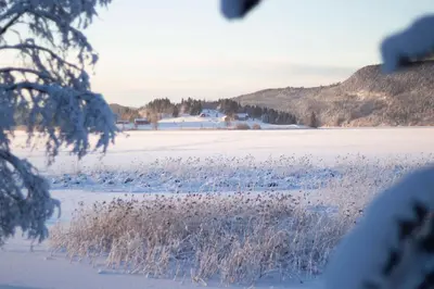 a field covered in snow with a field of grass at GapaLux in Levanger
