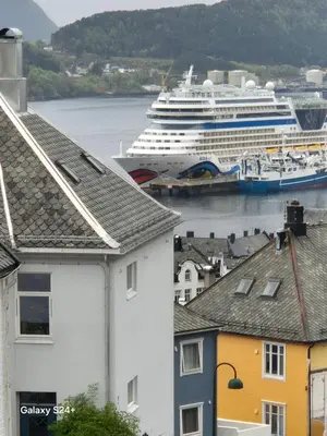 a cruise ship is docked in a harbor with houses at Duzy apartament w centrum Ålesund in Ålesund