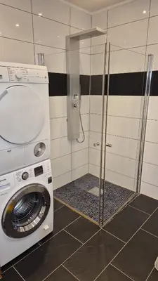 a washing machine in a bathroom with a washer at Duzy apartament w centrum Ålesund in Ålesund
