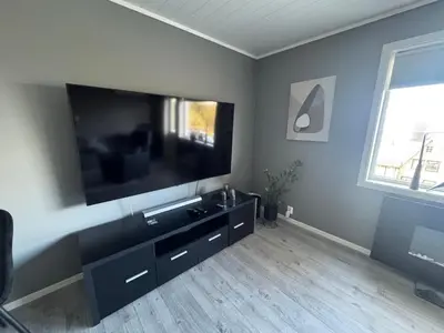 a living room with a large flat screen tv at Ålesund sentrum apartment in Ålesund