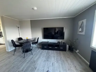 a living room with a table and a flat screen tv at Ålesund sentrum apartment in Ålesund