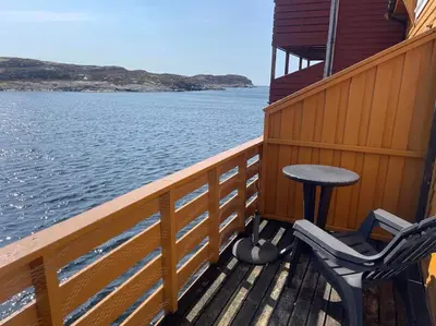 a balcony with two chairs and a table on a boat at Seaside apartment with balcony A1 in Nautnes