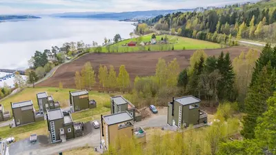 an aerial view of a group of houses on a hill with a lake at Moderne og familievennlig bolig, nær populær strand ved Mjøsa in Gjøvik