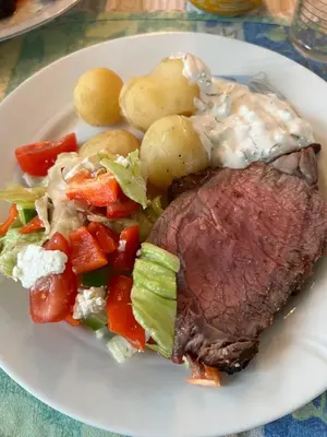 a plate of food with a steak and vegetables at Alværa Misionssenter Sommerhotel in Lavik