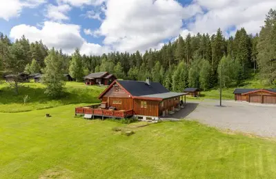 a large wooden cabin in a field of grass at Skogcamping in Bjørnstad