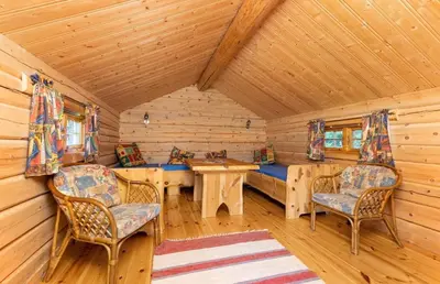 a dining room with a table and chairs in a log cabin at Skogcamping in Bjørnstad