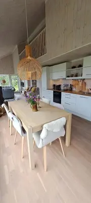 a kitchen with a wooden table with chairs and a chandelier at Steinstølen by Norgesbooking - cabin with a lovery view in Hol