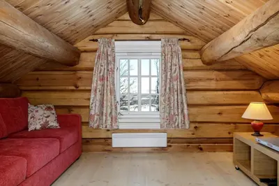 a living room with a red couch and a window at Cozy family cabin with stunning location on Golsfjellet in Golsfjellet
