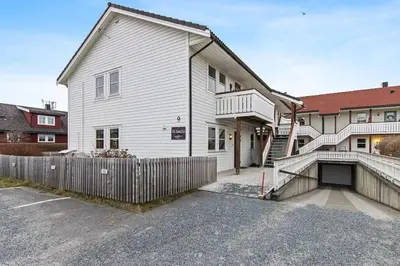 a white house with a fence in front of it at Nyoppusset leilighet midt i sentrum in Verdal