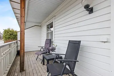 two chairs and a table on the porch of a house at Nyoppusset leilighet midt i sentrum in Verdal