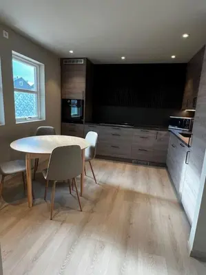 a kitchen with a table and chairs in a room at Nyoppusset leilighet midt i sentrum in Verdal