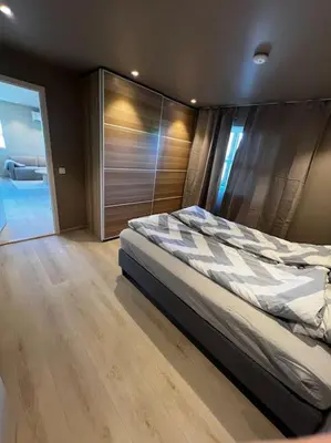a bedroom with a bed and a wooden floor at Nyoppusset leilighet midt i sentrum in Verdal