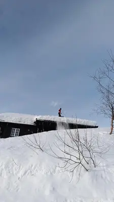 a person on a roof in the snow at Hytte i Myrkdalen in Helgatun