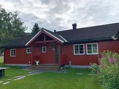 a red house with a red door and a yard at Villa Soltun in Ringebu